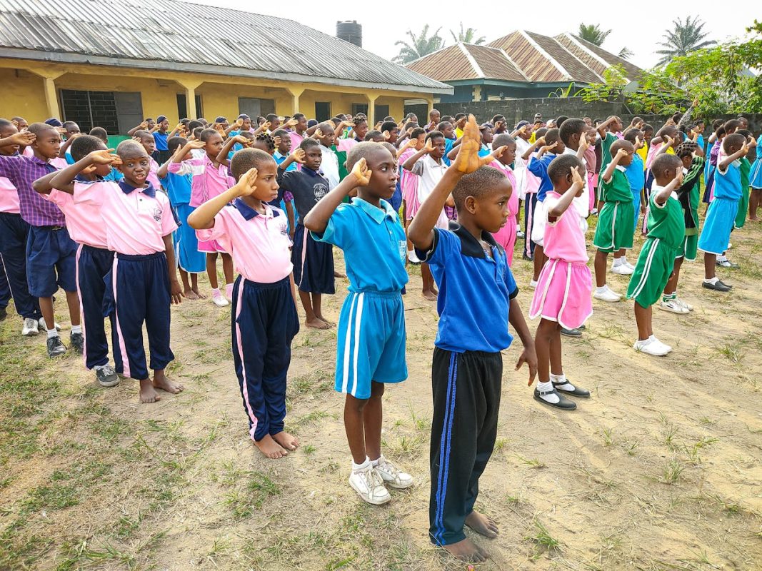 School children saluting during an educational activity.